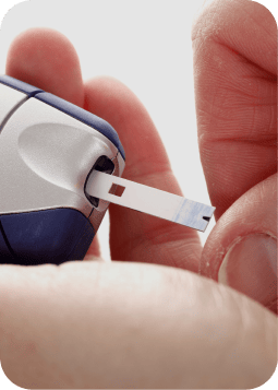 Glucometro in primo piano mentre si inserisce una piccola cartuccia per il test