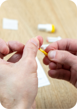 Mani che preparano una dose di medicinale in pillole, con flacetti e carta sul tavolo: processo di dosaggio domestico.