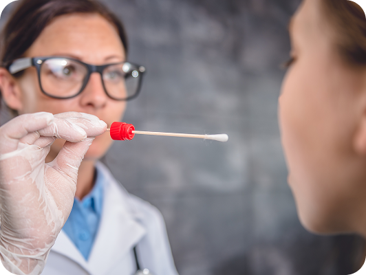 Medico con guanti tiene un cotton fioc rosso vicino al naso di un paziente per tampone