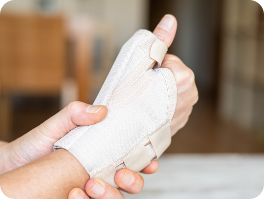 Fascia al polso in tessuto bianco con bendaggio elastico, immobilizzazione delicata ma sicura della mano.