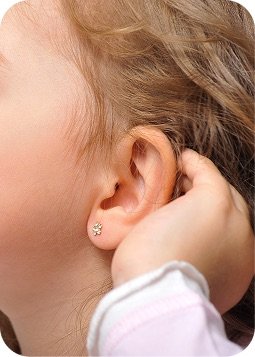 Orecchio di una bambina con orecchino stellina
