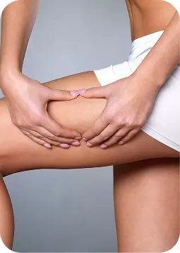 Primo piano sulle cosce: mani che fanno pressioni sui tessuti della parte esterna della coscia.