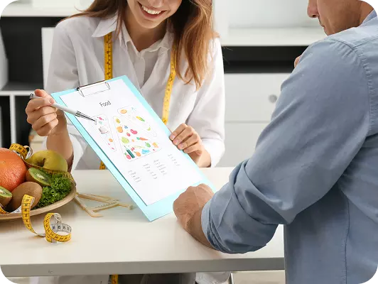 Due professionisti discutono una scheda alimentare con grafici, in un ambiente di consulto, vicino a frutta fresca e misuratori di potenziale.