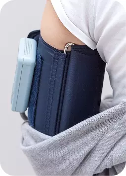 Dispositivo medico al braccio con tasca rialzata, supporto blu scuro e cavo, indossato sotto una maglietta.