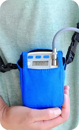 Dispositivo medico portatile in una custodia blu, display digitale e cinghie, con lettura 62.21 leggibile