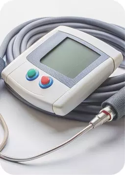 Dispositivo medico di controllo glyco: monitor portatile con cavo flessibile e due pulsanti colorati riporta in primo piano.