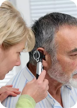 Uomo anziano che si fa controllare l’orecchio dal medico con uno strumento diagnostico